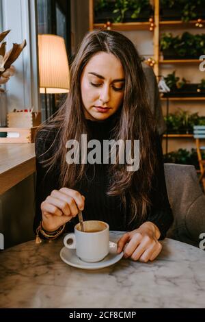Donna di bere il caffè nella caffetteria Foto Stock