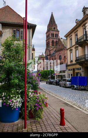 Grande chiesa in arenaria rossa con torre, ihe città vecchia di Munster, nei Vosgi montagne, Francia, Foto Stock