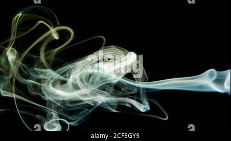 Il fumo astratto oscilcia il colore blu e giallo su sfondo nero. Elegante carta da parati curva colorata Foto Stock