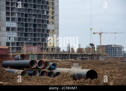 Tubi fognari neri per la posa di un sistema fognario esterno in un cantiere. Sistema di drenaggio sanitario per un edificio a più piani. Infrastruttura civile Foto Stock