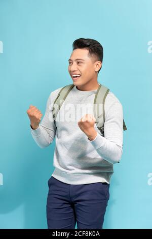 Felice studente di successo, uomo d'affari vincente, pugni pompati celebrando successo isolato sfondo blu. Foto Stock