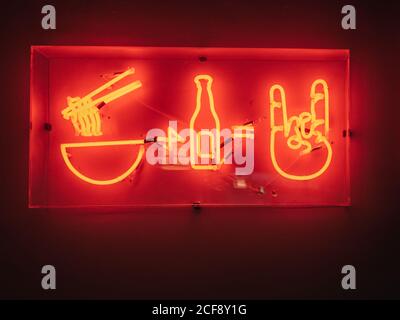 Cartello illuminato del ristorante asiatico che offre cibo e bevande appesi a parete Foto Stock