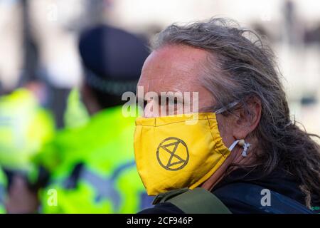 Ritratto di un uomo in maschera durante la manifestazione della ribellione estinzione, Piazza del Parlamento, Londra, 1 settembre 2020 Foto Stock