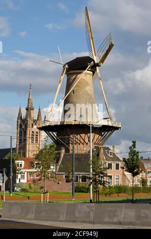 Delft, Paesi Bassi, 23 agosto 2020: Vista della Fenixstraat ricostruita al perimetro della città vecchia con il mulino a vento De Roos e la Chiesa Vecchia Foto Stock