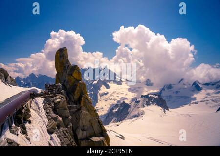 Bianchi picchi di montagna acuti nella neve che si innalzano fino a nuvoloso cielo Foto Stock