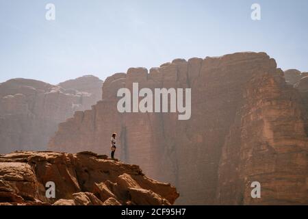 Donna in cima a una roccia a Wadi Rum Foto Stock