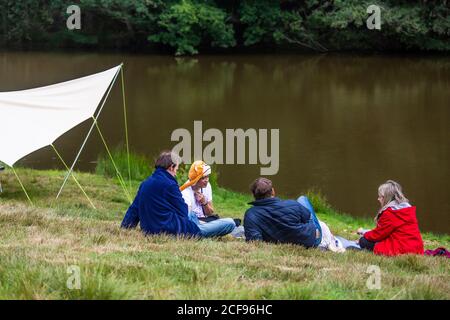 Rilassarsi vicino al lago nella zona benessere di We Non sono un festival socialmente distanziato evento a Pippingford Park - campeggio con atmosfera da festa Foto Stock