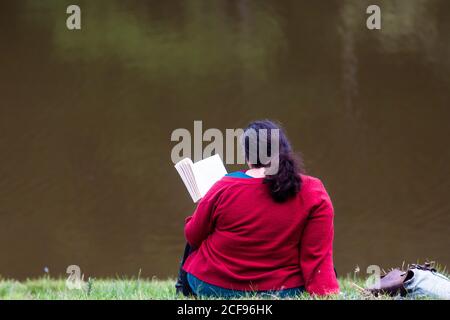 Agghiacciare e leggere un libro vicino al lago a We Non sono un festival socialmente distanziato evento a Pippingford Park - campeggio con atmosfera da festa Foto Stock