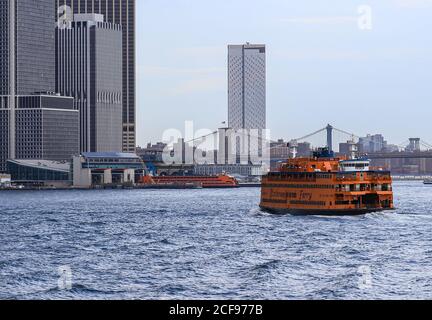 New York City, USA - 7 ottobre 2019: Un traghetto per Staten Island fuori dal porto di Manhattan. Un altro traghetto per Staten Island è in attesa per i passeggeri a. Foto Stock