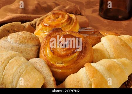 Primo piano di un cestino di prodotti da forno, tra cui croissant, biscotti, dolci alla cannella e molto altro Foto Stock