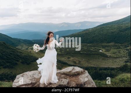 la sposa si prepara a lanciare il bouquet. Sposa in montagna. Foto Stock