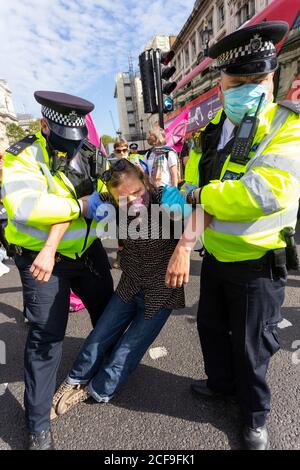 La polizia porta via una donna arrestata, manifestazione della ribellione estinzione, Piazza del Parlamento, Londra, 2 settembre 2020 Foto Stock
