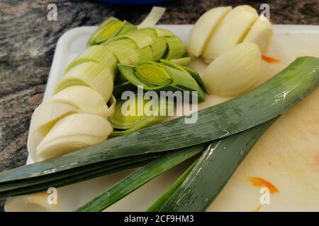 Un primo piano di cipolla verde tagliata cotta per la lattuga giace sulla tavola. Foto Stock