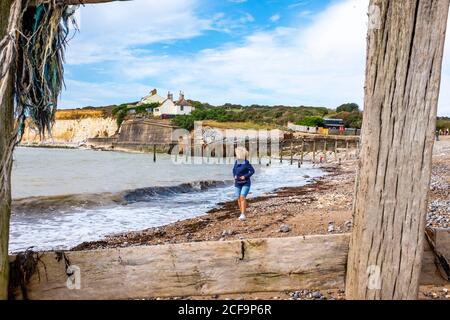 Seaford UK 04 settembre 2020 - UN camminatore gode la calda giornata di sole con un mix di nuvole a Cuckmere Haven vicino a Seaford sulla costa del Sussex oggi con i famosi cottage di guardia costiera arroccati sulle scogliere che stanno gradualmente erodendo via . : Credit Simon Dack / Alamy Live News Foto Stock