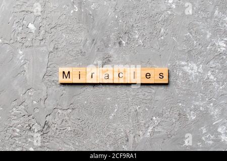 La parola miracoli scritta su blocco di legno. Miracoli testo su tavola di cemento per il vostro desing, concetto. Foto Stock