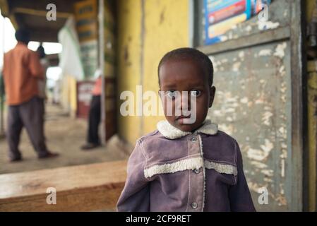 Uganda - Novembre 26 2016: Toddler africano calvo che guarda la macchina fotografica mentre si trova fuori in un villaggio Foto Stock