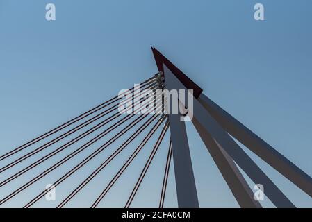 Basso angolo di costruzione di moderno ponte con metallo e. colonne e cavi in cemento in giornata di sole in città Foto Stock