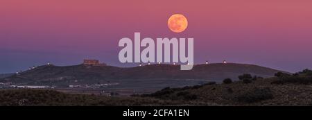 Da sotto pittoresco scenario di abbandonata fortezza invecchiata in cima Di montagna illuminata dalla Luna piena di notte a Toledo Foto Stock