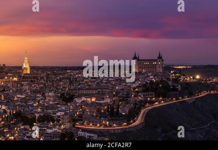 Dall'alto, il paesaggio incredibile della città vecchia illuminata in colorato Tramonto al crepuscolo a Toledo Foto Stock