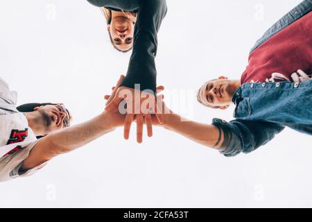 Un gruppo di giovani mettendo le mani insieme Foto Stock