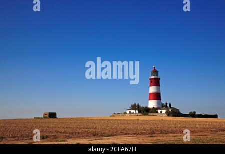 Una vista del faro e della scatola della due pill della guerra mondiale dal percorso della cima della scogliera nel Nord Norfolk a Happisburgh, Norfolk, Inghilterra, Regno Unito. Foto Stock