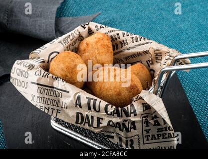 Da sopra chiocciera di deliziosi croccanti di pollo fritti avvolte In carta con testo spagnolo Foto Stock