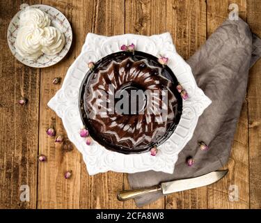 Vista dall'alto della torta al cioccolato con panna servita piastra in ceramica bianca su superficie in legno Foto Stock