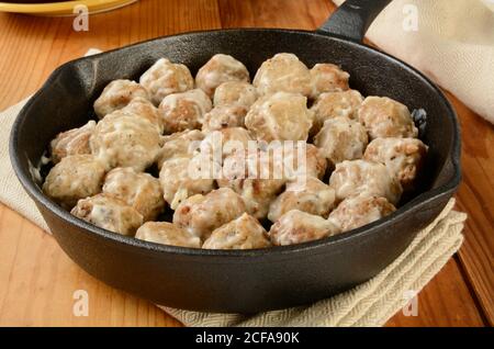 Una padella in ghisa di polpette svedesi in salsa di panna Foto Stock