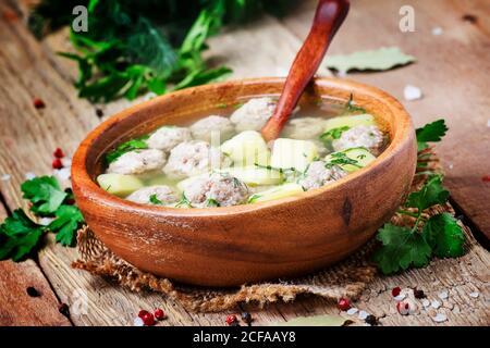 Zuppa fatta in casa con polpette di pollo e patate, stile rustico, sfondo in legno antico, fuoco selettivo Foto Stock