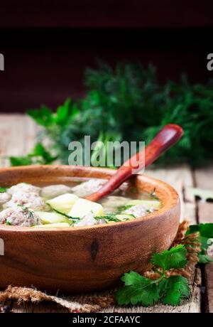 Zuppa fatta in casa con polpette di pollo e patate, stile rustico, sfondo in legno antico, fuoco selettivo Foto Stock