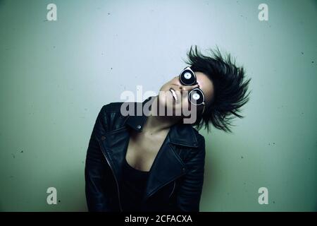 Forte giovane rocker femminile in giacca di pelle in studio Foto Stock