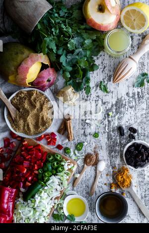 Da sopra mango maturo e mela con peperoni tritati e. cipolle e spezie per cucinare il mango chutney sul tavolo Foto Stock