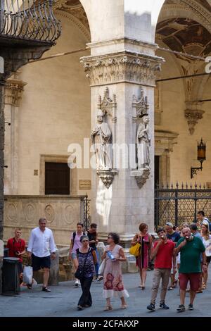 SIENA, ITALIA - LUGLIO 23,2017 : turisti vicino ad un bellissimo palazzo antico nella città medievale di Siena Foto Stock