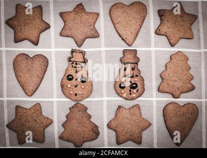 Decorato a mano dai bambini natale pan di zenzero biscotto pupazzo di neve figurine ammidi altri biscotti non decorati Foto Stock