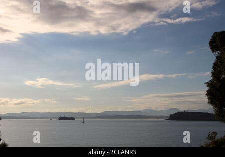 Vista panoramica del paesaggio in una mattinata estiva soleggiata con la penisola di Magdalena Palace Moors Island e una turbina eolica ancorata al mare Foto Stock