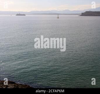 Vista panoramica del paesaggio in una mattinata estiva soleggiata con la penisola di Magdalena Palace Moors Island e una turbina eolica ancorata al mare Foto Stock