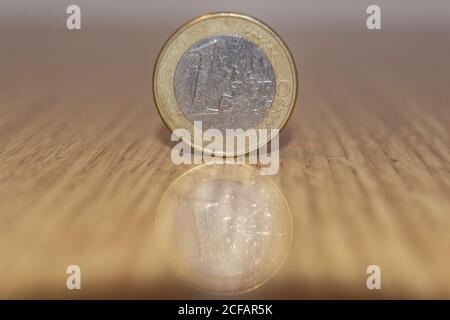 moneta da 1 euro con riflessione sul tavolo Foto Stock