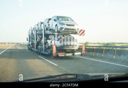 Rimorchio per trasporto auto su strada asfaltata. Vista dall'interno della vettura Foto Stock