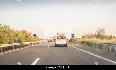 Vettura pilota o Escort dietro un autocarro con carico sovradimensionato. Vista dall'interno della vettura Foto Stock