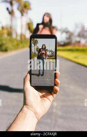 Foto scattante di una donna moderna elegante con smartphone nelle giornate di sole Foto Stock