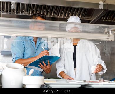 Colleghi che controllano la qualità del cibo in mensa Foto Stock