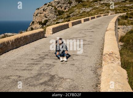 Donna seduta su un sentiero in pietra in campagna Foto Stock