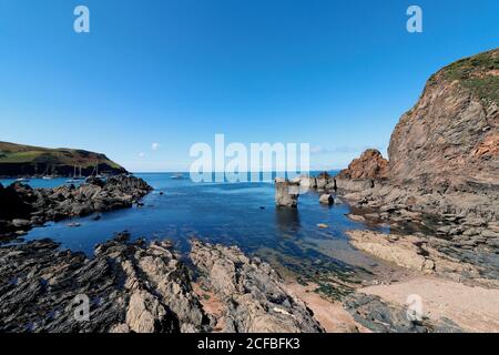 Una vista da Hope Cove con la bassa marea che guarda fuori al mare Foto Stock