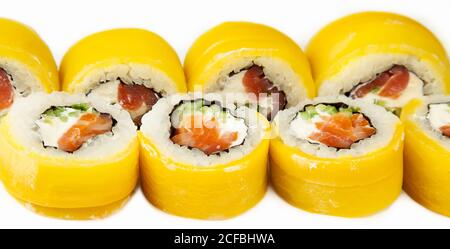Sushi roll con takuan e salmone affumicato su un piatto bianco, sushi giapponese classico. Cucina tradizionale giapponese con maki deliziosi pezzi di sushi per il menu del ristorante. Copia spazio Foto Stock
