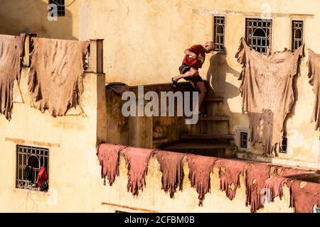 Uomo marocchino che lavora in conceria di cuoio a Fez Foto Stock