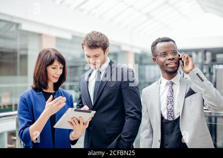 Team di colleghi multietnica lavorando insieme su atablet. Foto Stock