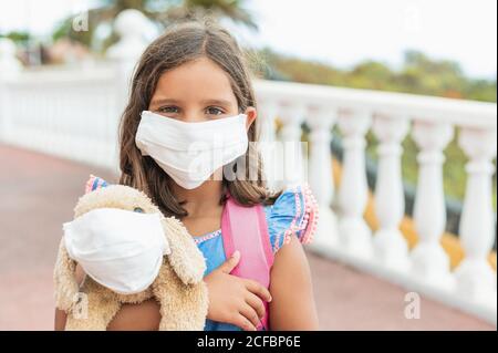 Protezione contro le malattie. Ritratto di una ragazza con maschera facciale igienica per prevenire infezioni, malattie, influenza o 2019-nCoV. Concetto di ritorno a scuola nel Foto Stock
