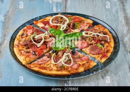 Pizza mista suprema dalla vista dall'alto su sfondo di legno. Foto Stock