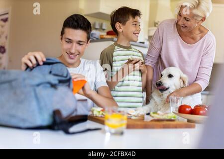 Madre che aiuta i suoi due figli a prepararsi per la scuola Foto Stock