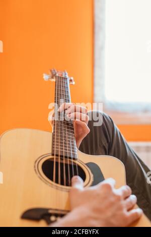 uomo che suona la chitarra sul letto Foto Stock